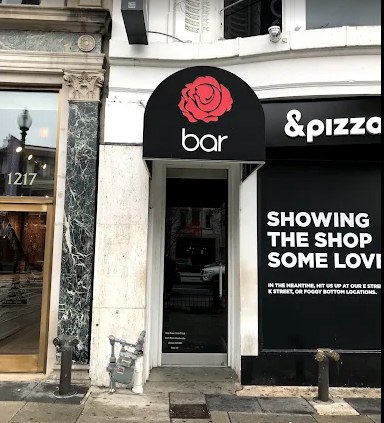 The Rosebar entrance on a Washington, DC street, a black awning with a red rose logo
